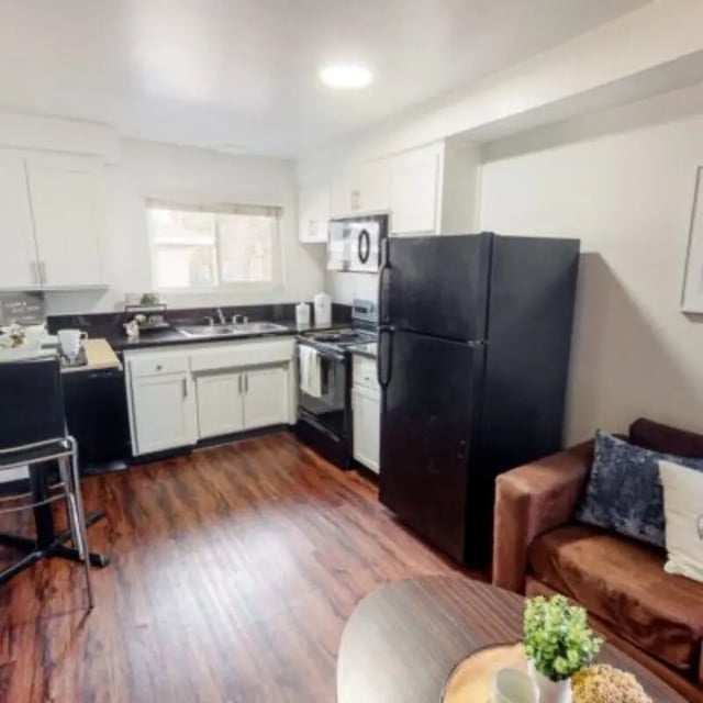 Kitchen with cabinets fridge stove and seating living room. at Capri at Isla Vista Apartments in Isla Vista Student Accommodation