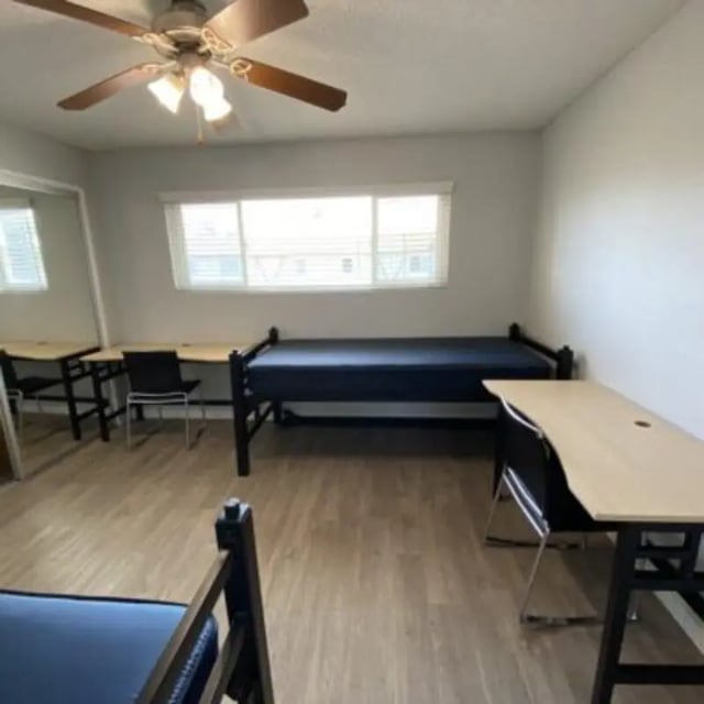 Two beds desks and chairs dorm room at Capri at Isla Vista Apartments in Isla Vista Student Accommodation