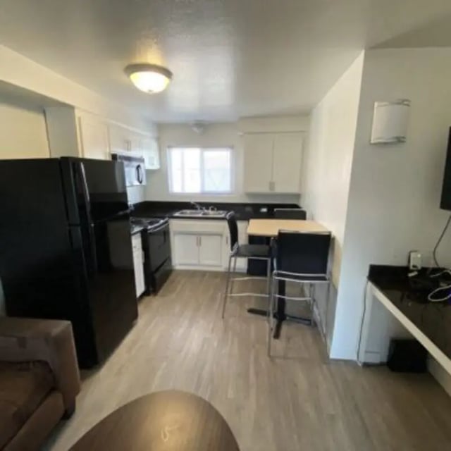 Kitchen with refrigerator stove table chairs living room at Capri at Isla Vista Apartments in Isla Vista Student Accommodation