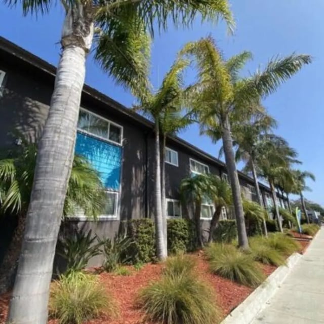 Palm trees line dark building exterior exterior at Capri at Isla Vista Apartments in Isla Vista Student Accommodation