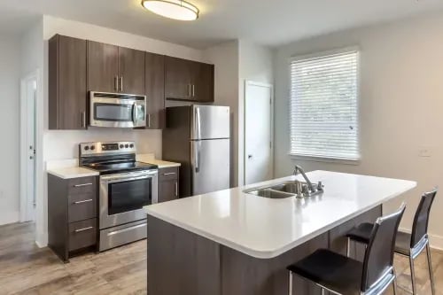 Modern kitchen island with appliances and seating kitchen at 1301 Hillsborough Apartments in Raleigh Student Accommodation