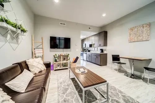 Sofa TV coffee table dining area kitchen living room at 1301 Hillsborough Apartments in Raleigh Student Accommodation
