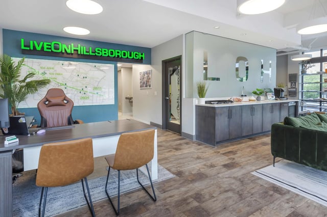 Office desk chairs plant and coffee counter office at 1301 Hillsborough Apartments in Raleigh Student Accommodation