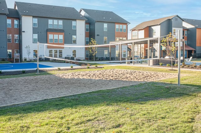 Volleyball court and apartments exterior at Aspen Heights Fayetteville in Fayetteville Student Accommodation