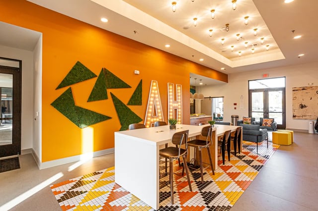 Modern communal area with tables chairs and sofa Living room at Aspen Heights Fayetteville in Fayetteville Student Accommodation
