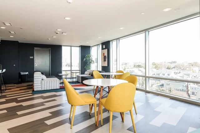 Yellow chairs and white tables lounge area living room at Aspen Heights Towson in Towson Student Accommodation
