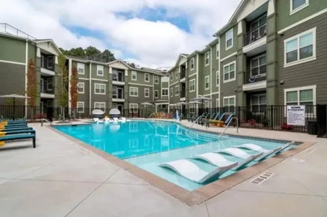Pool with lounge chairs and apartment buildings exterior at 14 SixtyFive in Kennesaw Student Accommodation