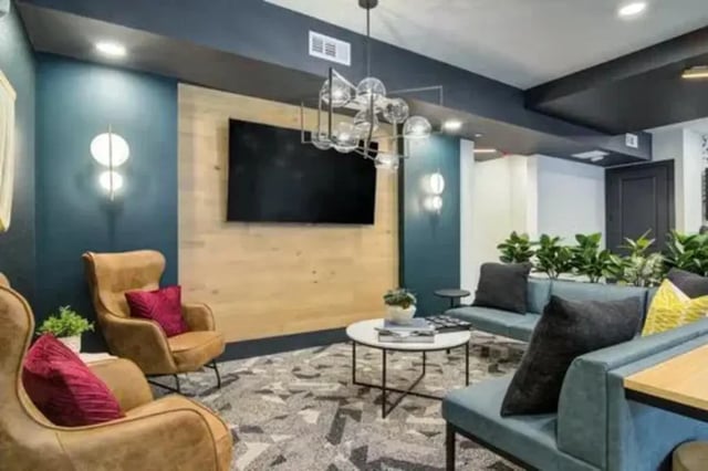 Modern living area with couches chairs TV and plants living room at 14 SixtyFive in Kennesaw Student Accommodation