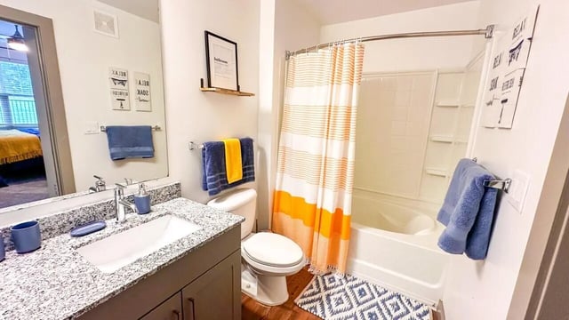 Sink toilet shower with orange striped curtain Bathroom at 14 SixtyFive in Kennesaw Student Accommodation