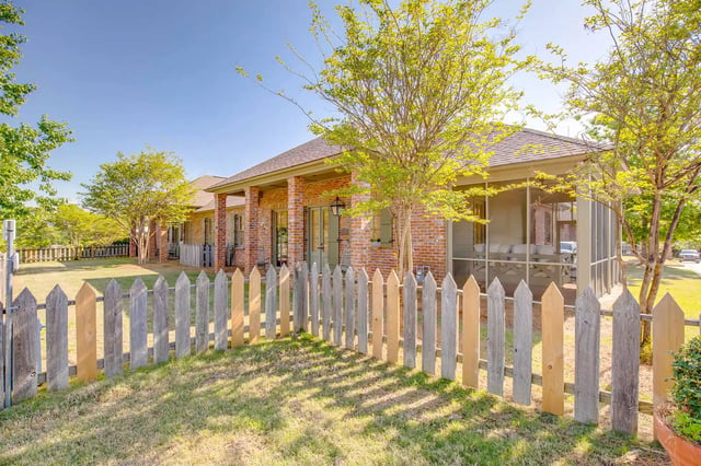 Brick house with screened porch and fence exterior at The Cottages at Hooper Hollow in Oxford Student Accommodation