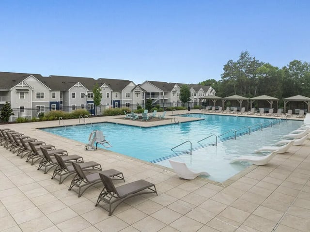 Swimming pool with lounge chairs and apartment buildings exterior at Aspen Heights University City in Charlotte Student Accommodation