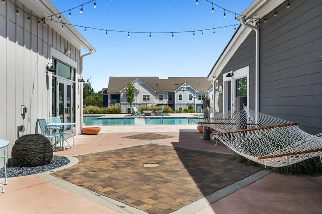Hammocks by poolside with apartment buildings exterior at Aspen Heights University City in Charlotte Student Accommodation