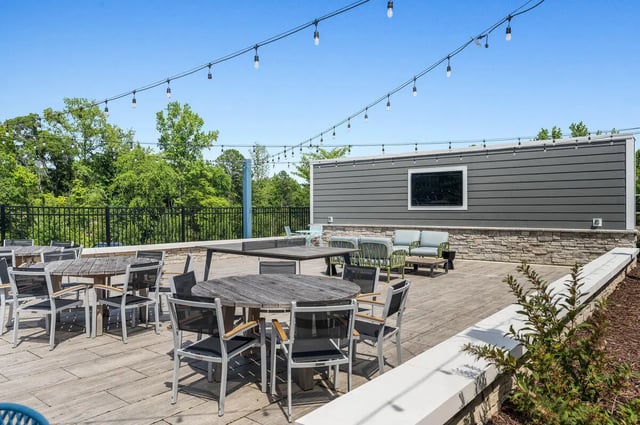 Wooden tables and chairs with outdoor seating area exterior at Aspen Heights University City in Charlotte Student Accommodation