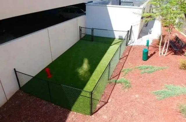 Fenced grass area with red toy and green bin exterior at Aspen Springfield in Springfield Student Accommodation