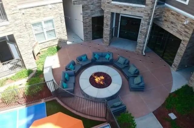 Circular seating around fire pit outdoors living room at Aspen Springfield in Springfield Student Accommodation