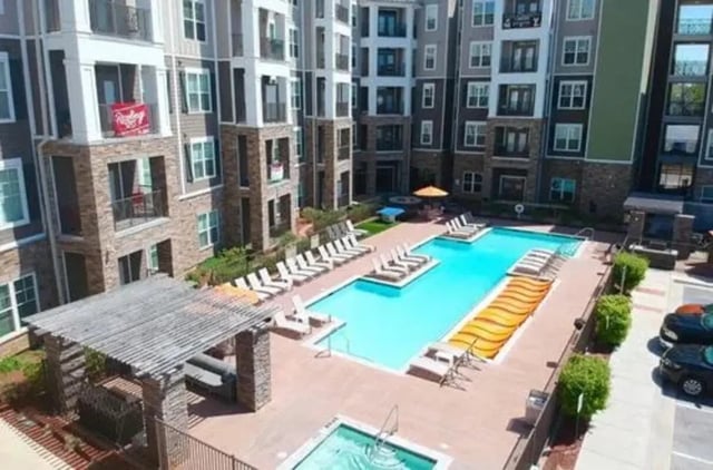 Apartment complex with pool lounge chairs and hot tub exterior at Aspen Springfield in Springfield Student Accommodation