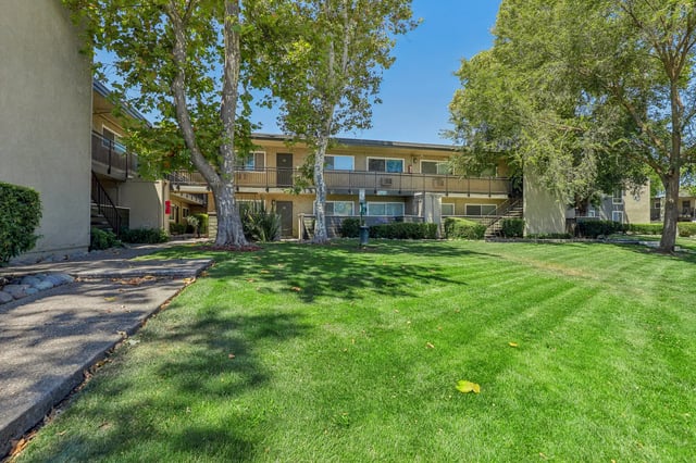 Apartment buildings with balconies and green lawn exterior at The Spoke in Davis Student Accommodation