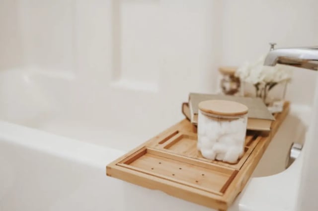 Bamboo bath caddy with cotton balls books flowers bathroom at Alpine Village in Provo Student Accommodation