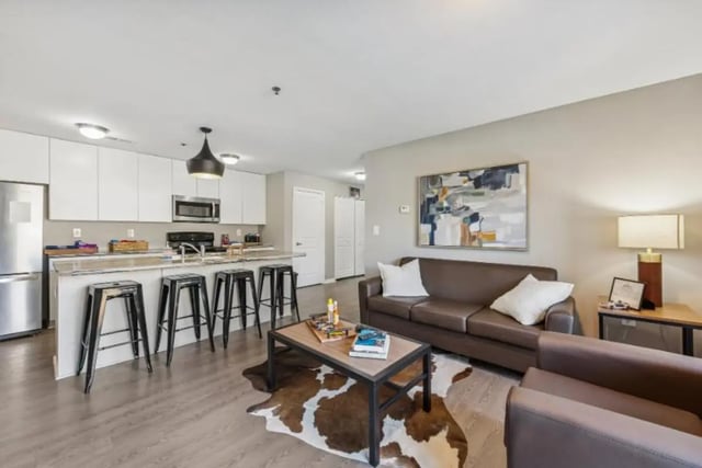 Kitchen island bar stools brown sofa coffee table living room at The Harbor in Johnson City Student Accommodation
