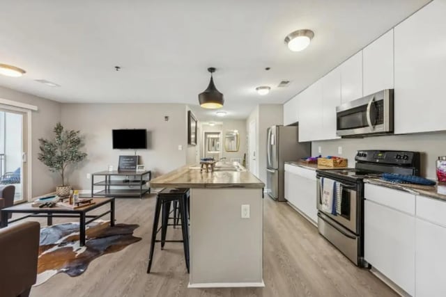 Island kitchen with living area and television living kitchen at The Harbor in Johnson City Student Accommodation