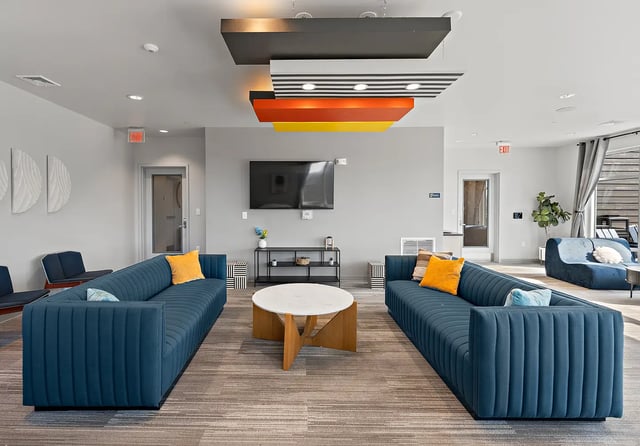 Blue sofas coffee table TV lounge area at Aspen State College in State College Student Accommodation
