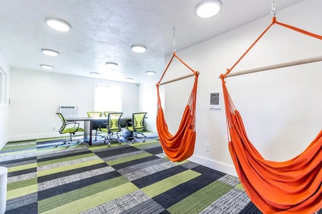 Orange hammocks and meeting table with chairs common area at Birch Plaza and Birchwood Apartments in Rexburg Student Accommodation
