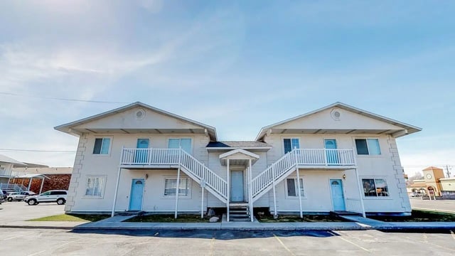 Exterior view of apartment building with white siding at Birch Plaza and Birchwood Apartments in Rexburg Student Accommodation