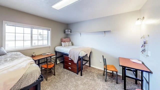 Two beds desks chairs and decor bedroom at Birch Plaza and Birchwood Apartments in Rexburg Student Accommodation