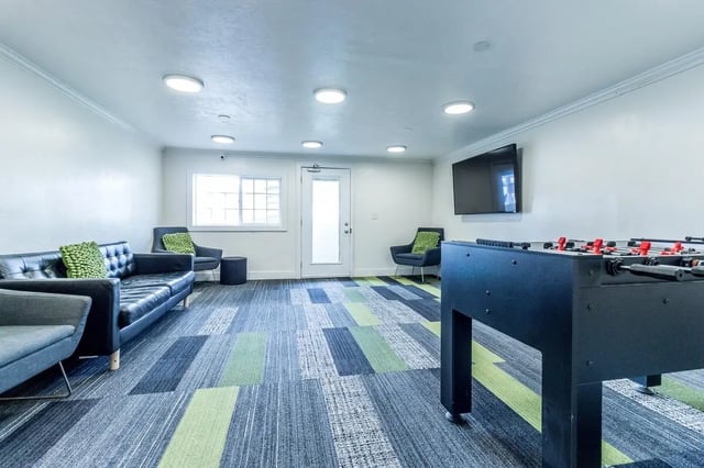 Sofas chairs foosball table television living room at Birch Plaza and Birchwood Apartments in Rexburg Student Accommodation