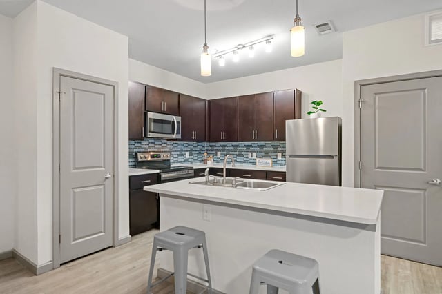 Modern kitchen with stainless steel appliances and island kitchen at Altitude Apartments in Houston Student Accommodation
