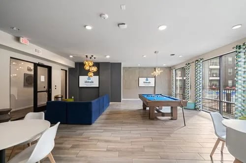 Pool table blue couch tables white chairs living room at Altitude Apartments in Houston Student Accommodation