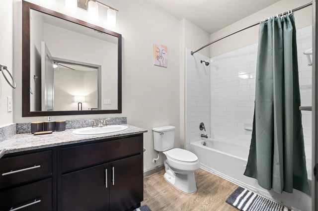 Sink toilet bathtub with shower curtain bathroom at Altitude Apartments in Houston Student Accommodation