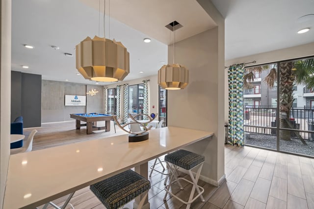 Bar with stools pool table and blue sofa living area at Altitude Apartments in Houston Student Accommodation