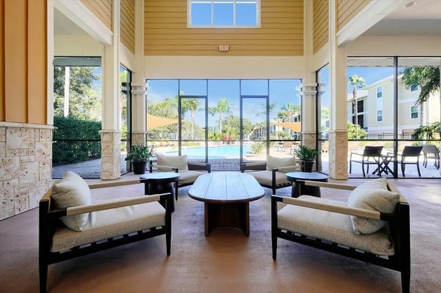 Lounge chairs coffee table pool view living room at Eagle Landing in Daytona Beach Student Accommodation