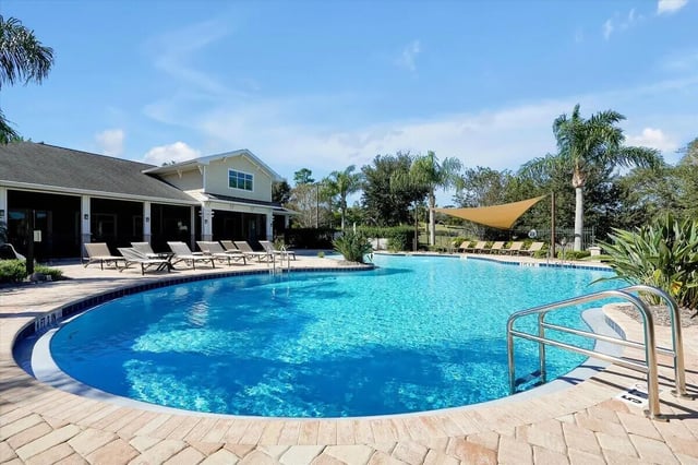 Resort-style pool with lounge chairs and building exterior. Swimming pool. at Eagle Landing in Daytona Beach Student Accommodation