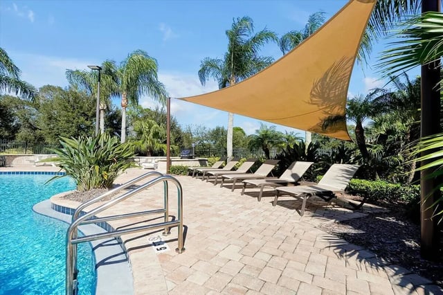 Poolside lounge chairs under shade canopy Swimming pool area at Eagle Landing in Daytona Beach Student Accommodation