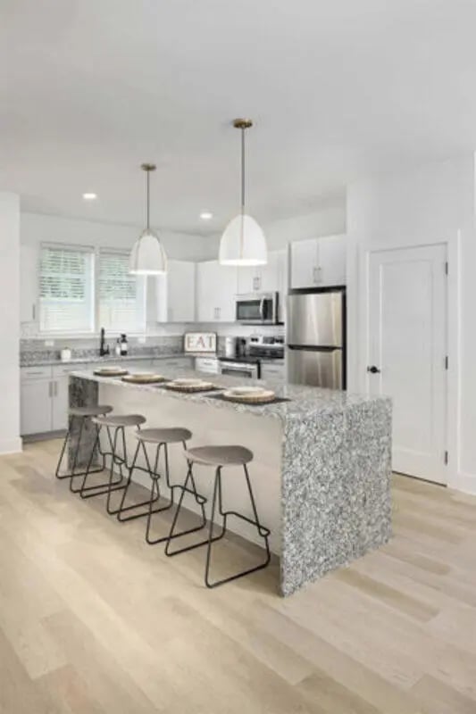 Kitchen island with stools granite countertop and cabinets kitchen at Prospect Row in Tallahassee Student Accommodation