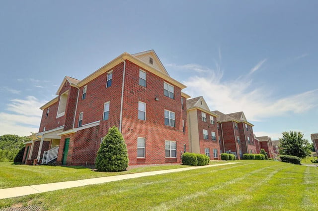 Brick apartment buildings with green lawns exterior at Eagles Landing Apartments in Cookeville Student Accommodation