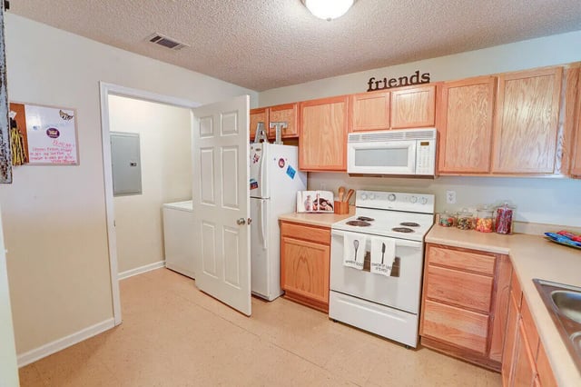 Refrigerator stove cabinets countertop and microwave kitchen at Eagles Landing Apartments in Cookeville Student Accommodation