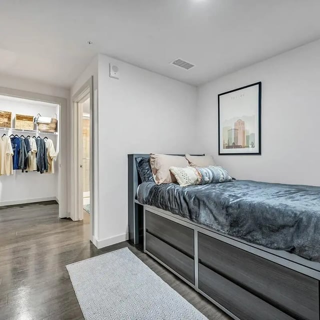 Bed with storage closet with clothes Bedroom at Aspire Tucson Apartments in Tucson Student Accommodation