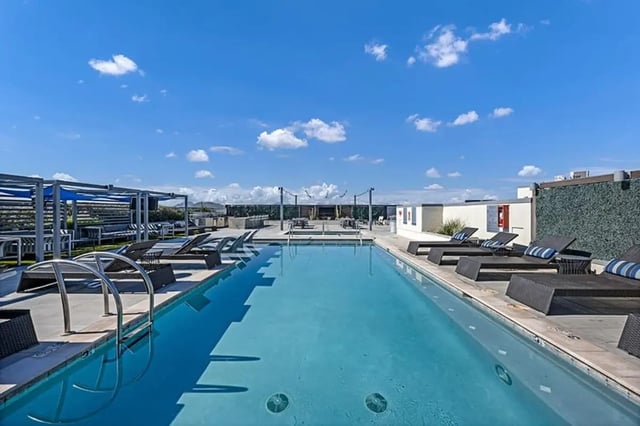Long pool lounge chairs cabanas tables outdoor amenity area at Aspire Tucson Apartments in Tucson Student Accommodation
