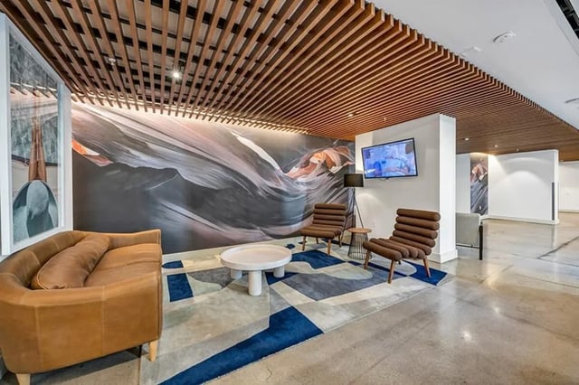 Sofa artwork chairs coffee table TV living room at Aspire Tucson Apartments in Tucson Student Accommodation