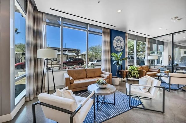 Brown sofas white chairs round coffee table living room at Aspire Tucson Apartments in Tucson Student Accommodation
