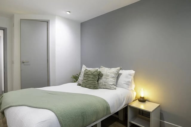 Bed pillows green throw bedside lamp bedroom at The Bridge Phase II in Newcastle Upon Tyne Student Accommodation