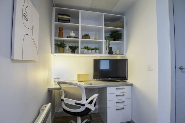 Desk with chair, shelving, and television study area at The Bridge Phase II in Newcastle Upon Tyne Student Accommodation