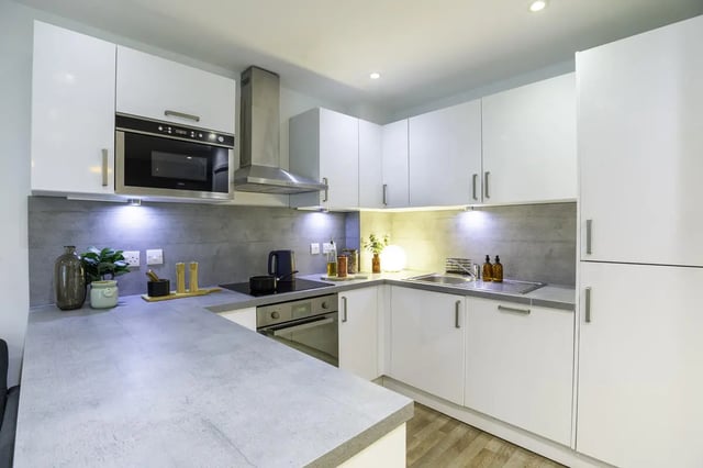 Modern white kitchen with microwave oven and sink kitchen at The Bridge Phase II in Newcastle Upon Tyne Student Accommodation