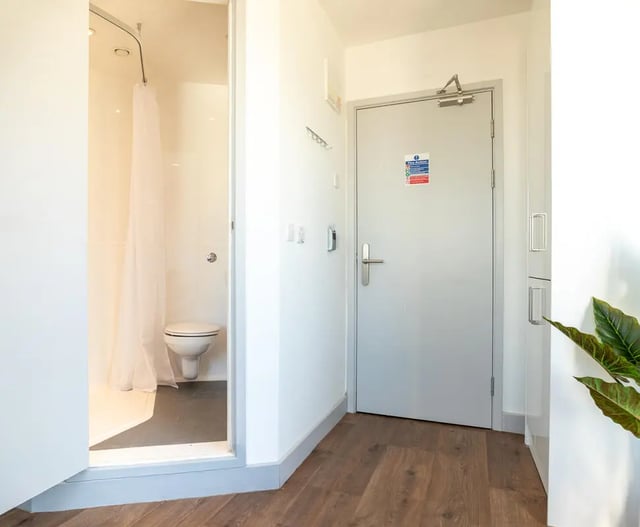 Shower stall with toilet and hallway exterior at The Bridge Phase II in Newcastle Upon Tyne Student Accommodation
