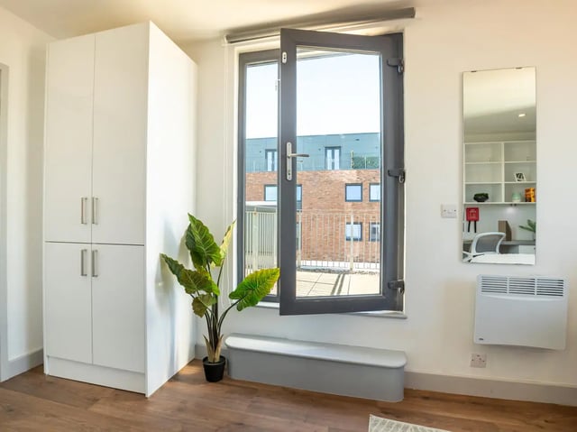 White wardrobe plant bench and mirror study area at The Bridge Phase II in Newcastle Upon Tyne Student Accommodation