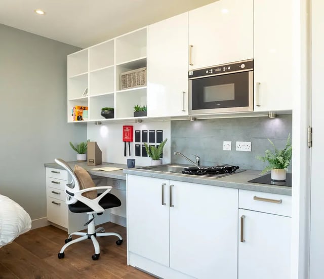 Desk chair microwave sink cabinets shelves kitchen area at The Bridge Phase II in Newcastle Upon Tyne Student Accommodation