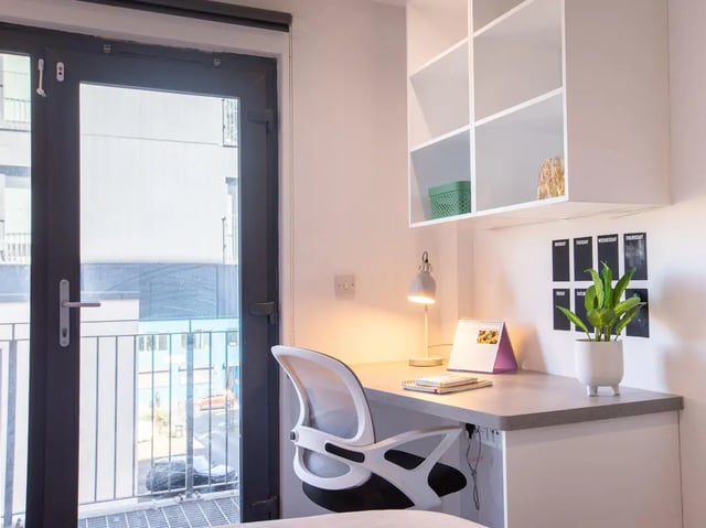 Desk lamp calendar chair plant and shelves Study area at The Bridge Phase II in Newcastle Upon Tyne Student Accommodation